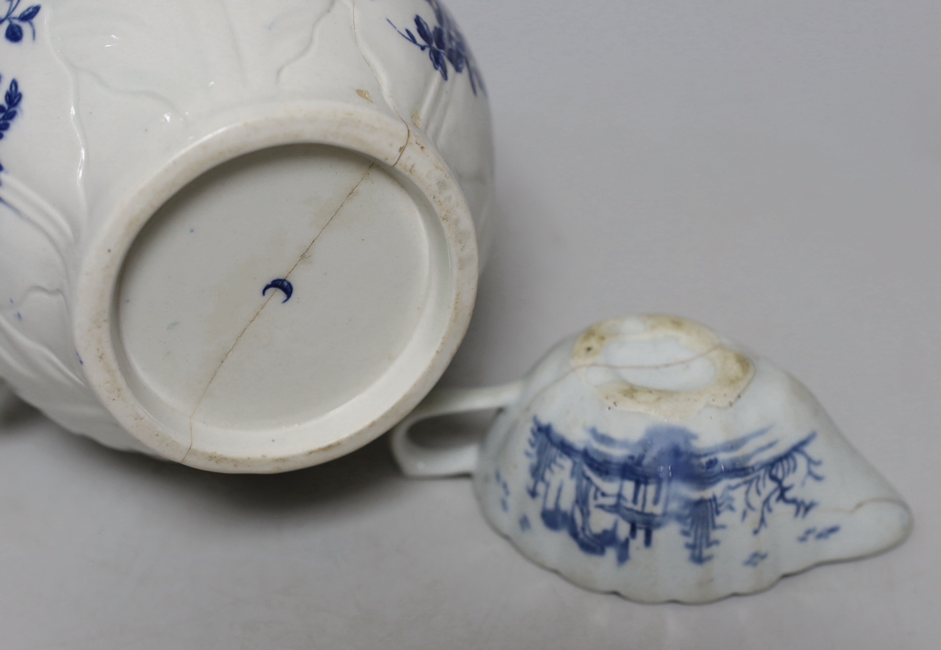 An 18th century Worcester blue and white cabbage-leaf mask jug, two similar sauceboats and an 18th century English blue and white sauceboat, a/f, tallest 19cm high